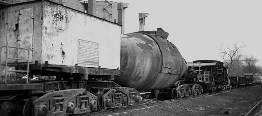 a large torpedo car on rails used to transport molten metal at a steel mill