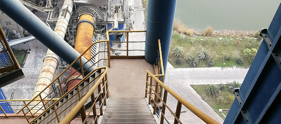 looking down the length of an industrial rotary kiln, with the compact HCR120D Demolition Robot visible dismantling inside.